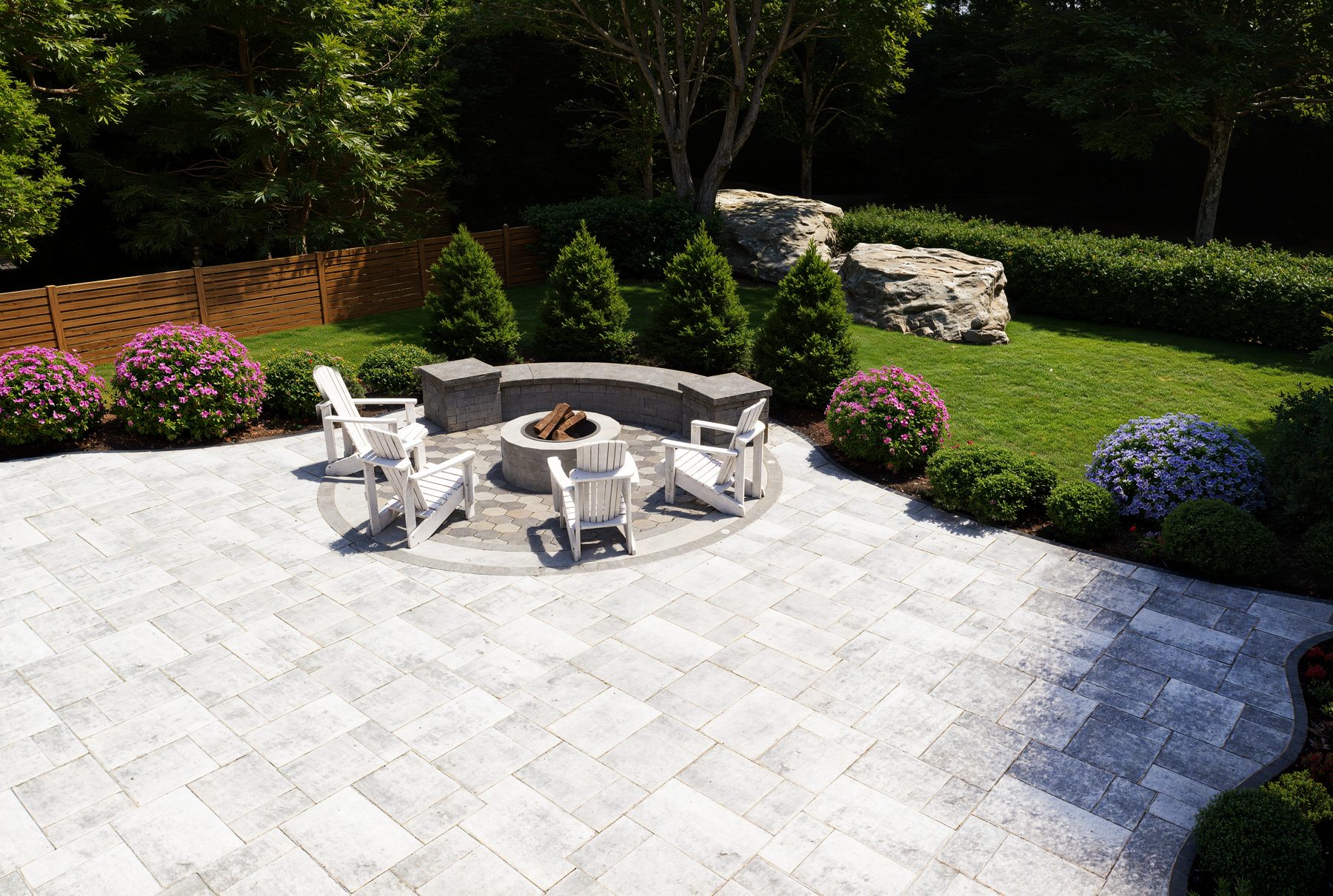 3D rendering of a paver patio with fire pit and white chairs
