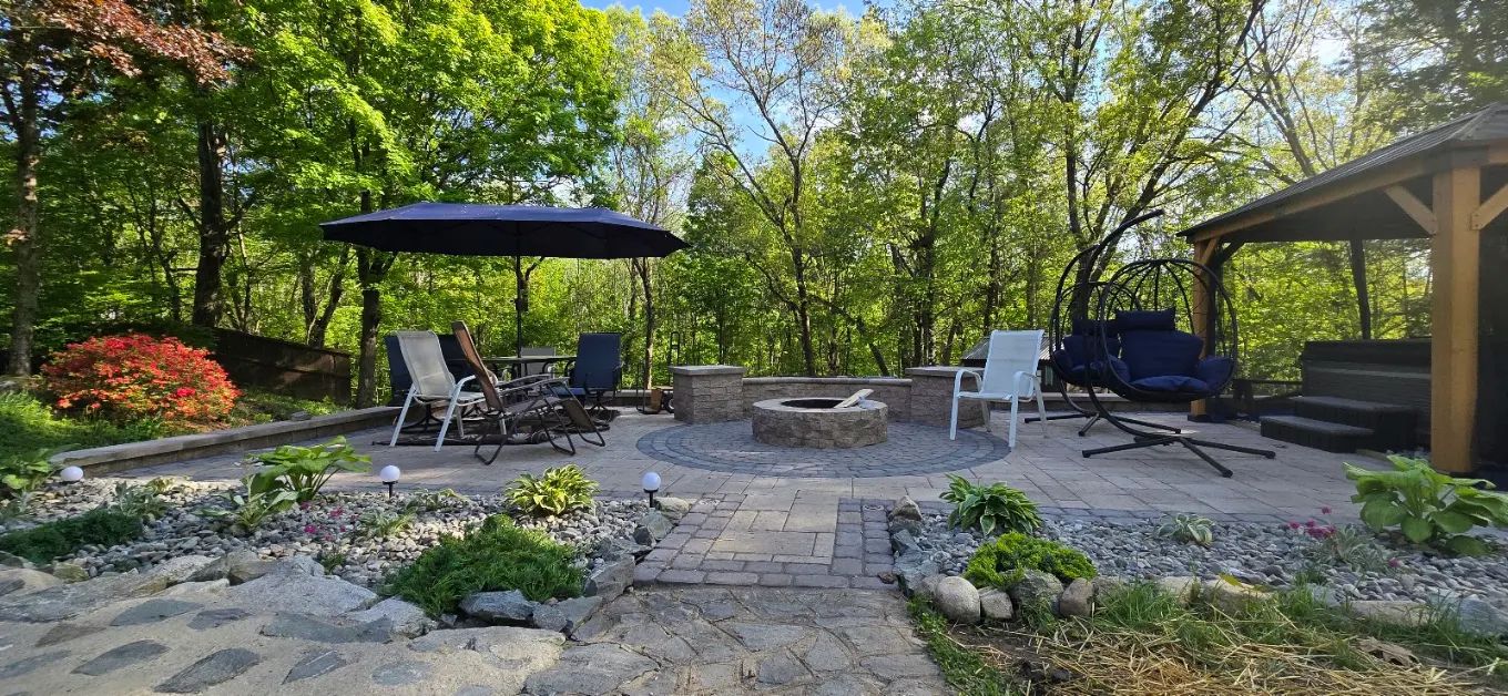 Backyard patio with pergola, fire pit, plantings and stone paths near Concord, NH