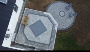 Aerial view of circular paver patio with fire pit and seat wall in progress, Concord, NH area