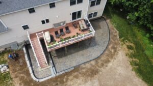 Aerial view of a paver patio build behind a home in the Concord, NH area
