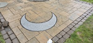 Paver patio detail with circular inlay by Globe Green in the Concord, NH area