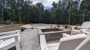 Paver patio with fire pit seen from a deck, Concord, NH area